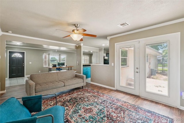810 N 3rd St, Jenks, OK 74037 - living room with crown molding, a textured ceiling, plenty of natural light, wood finished floors, and a ceiling fan