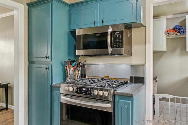 810 N 3rd St, Jenks, OK 74037 - kitchen with appliances with stainless steel finishes, blue cabinetry, and dark countertops