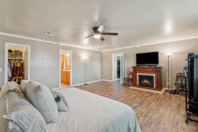810 N 3rd St, Jenks, OK 74037 - bedroom with light wood finished floors, ornamental molding, a spacious closet, ceiling fan, and ensuite bath