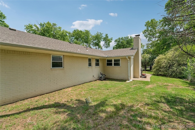 810 N 3rd St, Jenks, OK 74037 - back of property with a chimney, brick siding, a yard, and roof with shingles