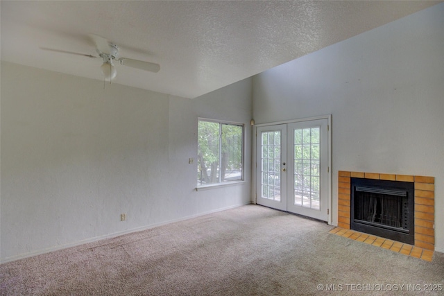 1730 E 67th St Unit K102, Tulsa, OK 74136 - unfurnished living room featuring carpet flooring, ceiling fan, a tile fireplace, french doors, and high vaulted ceiling