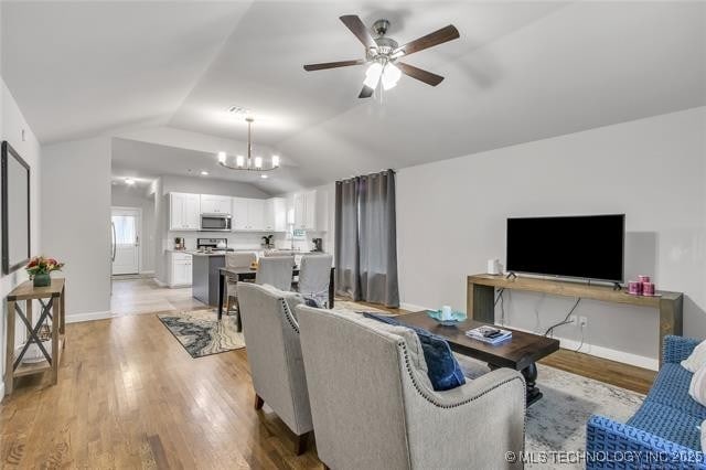 1332 N Denver Ave, Tulsa, OK 74106 - living area featuring vaulted ceiling, light wood-style flooring, a chandelier, and a ceiling fan