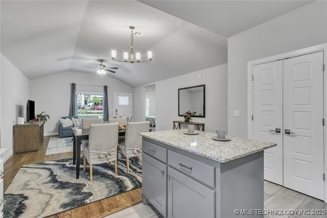 1332 N Denver Ave, Tulsa, OK 74106 - kitchen with a chandelier, vaulted ceiling, a center island, pendant lighting, and a ceiling fan