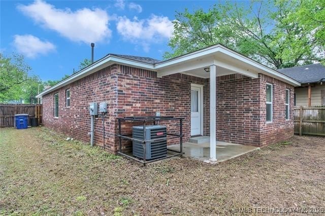 1332 N Denver Ave, Tulsa, OK 74106 - view of home's exterior featuring brick siding and a fenced backyard