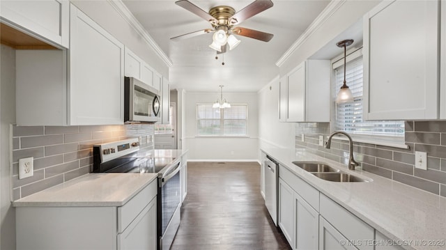 2974 E 77th Pl, Tulsa, OK 74136 - kitchen with stainless steel appliances, decorative backsplash, white cabinetry, dark wood-style flooring, and crown molding