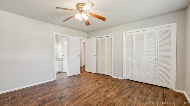2974 E 77th Pl, Tulsa, OK 74136 - unfurnished bedroom featuring dark wood finished floors, multiple closets, ceiling fan, and connected bathroom