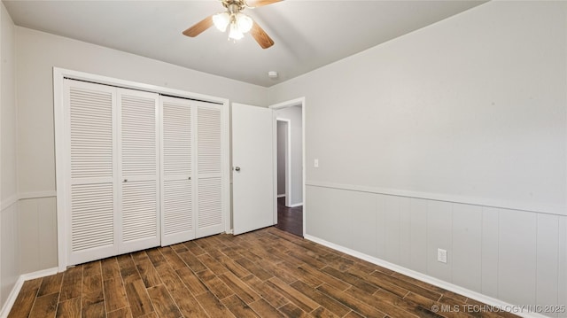 2974 E 77th Pl, Tulsa, OK 74136 - unfurnished bedroom with dark wood-style flooring, a wainscoted wall, a closet, and a ceiling fan