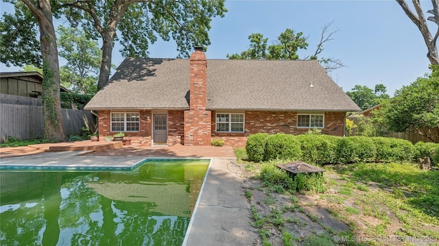 2974 E 77th Pl, Tulsa, OK 74136 - back of house with roof with shingles, a chimney, a patio area, and brick siding
