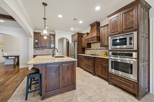 1956 E 172nd St S, Mounds, OK 74047 - kitchen with appliances with stainless steel finishes, arched walkways, crown molding, premium range hood, and decorative backsplash