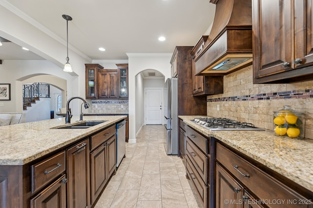 1956 E 172nd St S, Mounds, OK 74047 - kitchen featuring arched walkways, custom range hood, stainless steel appliances, backsplash, and pendant lighting