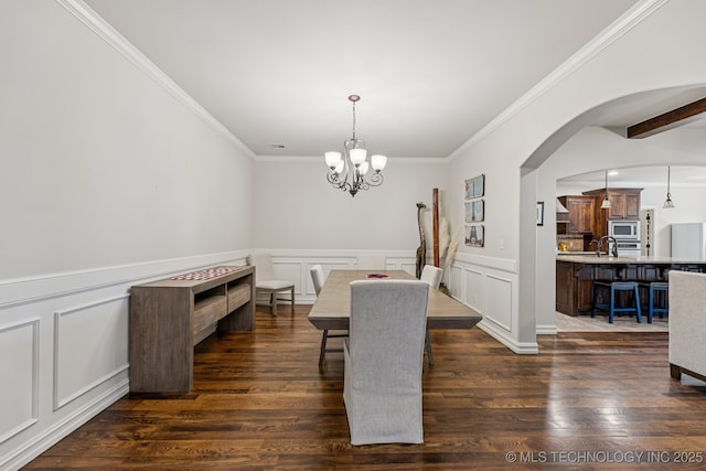1956 E 172nd St S, Mounds, OK 74047 - dining room with a decorative wall, crown molding, a chandelier, dark wood-style flooring, and arched walkways