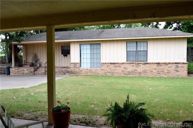 13050 S 143rd Ave E, Broken Arrow, OK 74011 - view of front of home with brick siding, a front lawn, board and batten siding, and a shingled roof