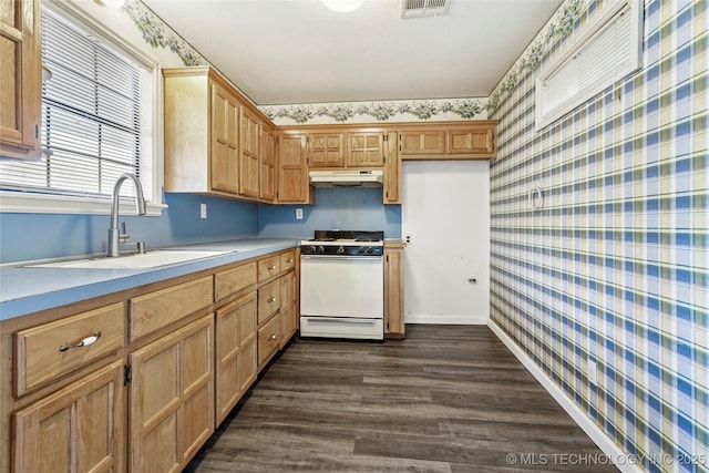 13050 S 143rd Ave E, Broken Arrow, OK 74011 - kitchen featuring white range with gas cooktop, wallpapered walls, under cabinet range hood, dark wood finished floors, and light countertops