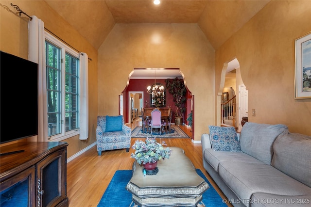 9034 S Maplewood Ave, Tulsa, OK 74137 - living room featuring arched walkways, wood finished floors, a chandelier, stairway, and high vaulted ceiling