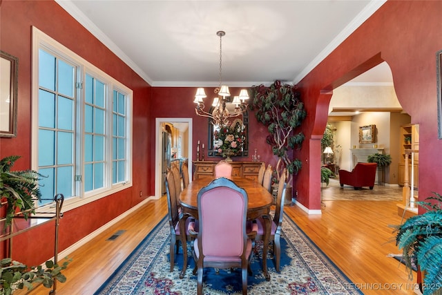 9034 S Maplewood Ave, Tulsa, OK 74137 - dining area with wood finished floors, a chandelier, and crown molding