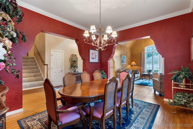 9034 S Maplewood Ave, Tulsa, OK 74137 - dining area featuring a chandelier, wood finished floors, stairs, ornamental molding, and arched walkways