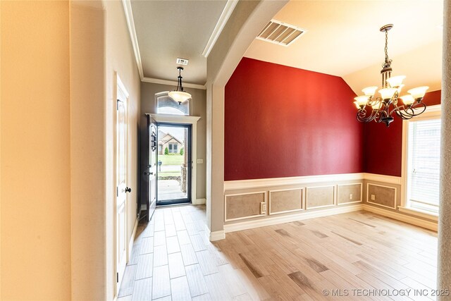 18312 E 46th St, Tulsa, OK 74134 - entrance foyer with a chandelier, healthy amount of natural light, ornamental molding, wood finished floors, and wainscoting