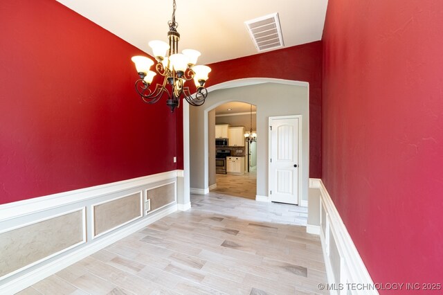 18312 E 46th St, Tulsa, OK 74134 - hall featuring a chandelier, arched walkways, and light wood-type flooring
