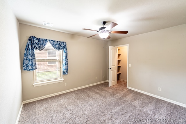 18312 E 46th St, Tulsa, OK 74134 - unfurnished bedroom with carpet flooring, ceiling fan, and a walk in closet