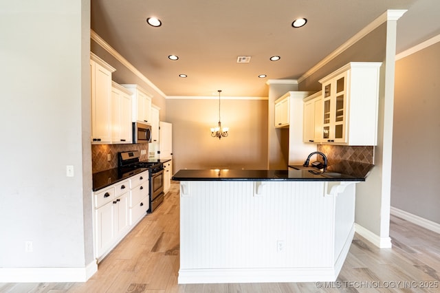 18312 E 46th St, Tulsa, OK 74134 - kitchen with appliances with stainless steel finishes, a peninsula, dark countertops, a breakfast bar, and recessed lighting
