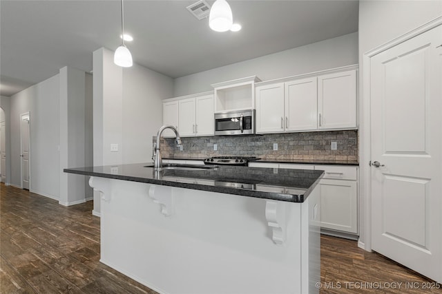 10387 S Nathan St, Jenks, OK 74037 - kitchen featuring stainless steel microwave, dark wood-style flooring, backsplash, and white cabinets