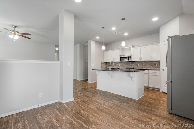 10387 S Nathan St, Jenks, OK 74037 - kitchen with appliances with stainless steel finishes, dark countertops, ceiling fan, backsplash, and white cabinetry