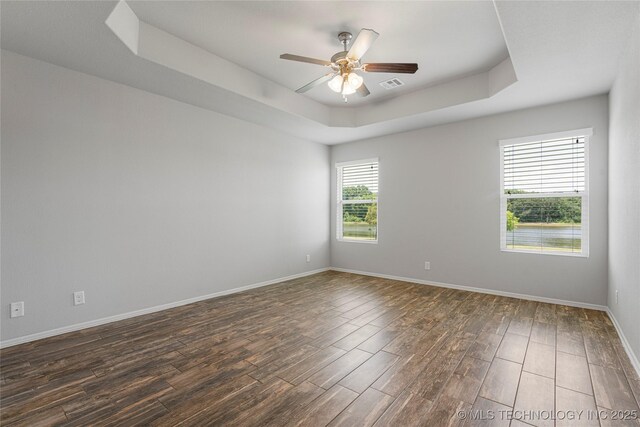 10387 S Nathan St, Jenks, OK 74037 - spare room with a raised ceiling, a ceiling fan, and dark wood-style flooring