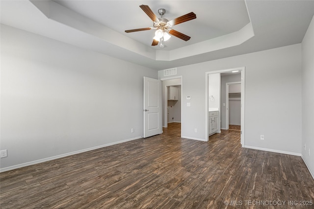 10387 S Nathan St, Jenks, OK 74037 - unfurnished bedroom with a tray ceiling, dark wood-style floors, ceiling fan, and a spacious closet