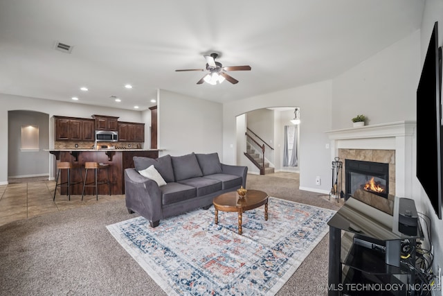 1620 E Boston Ct, Broken Arrow, OK 74012 - living room featuring arched walkways, light carpet, ceiling fan, a tile fireplace, and recessed lighting