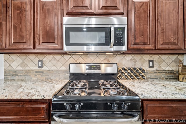 1620 E Boston Ct, Broken Arrow, OK 74012 - kitchen with stainless steel microwave, range with gas cooktop, tasteful backsplash, and light stone counters