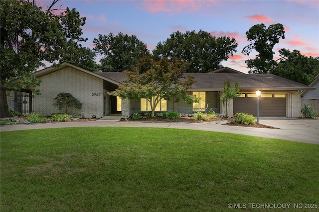 2962 E 56th Ct, Tulsa, OK 74105 - view of front of house with driveway, an attached garage, brick siding, and a front yard