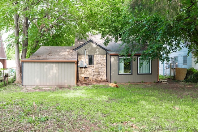 812 N Delaware Pl, Tulsa, OK 74110 - view of front of home featuring stone siding, a front lawn, and a shingled roof