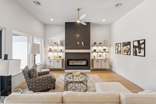 12622 S Granite Ave E, Bixby, OK 74008 - living room featuring a glass covered fireplace, a ceiling fan, wood finished floors, and recessed lighting