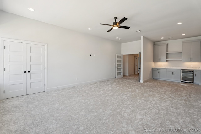 12622 S Granite Ave E, Bixby, OK 74008 - unfurnished living room featuring wine cooler, light colored carpet, recessed lighting, a ceiling fan, and bar