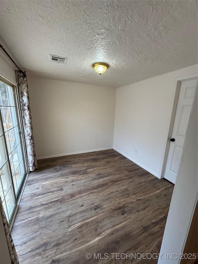 14274 W Clyde Maher, Tahlequah, OK 74464 - unfurnished room featuring plenty of natural light, dark wood-type flooring, and a textured ceiling