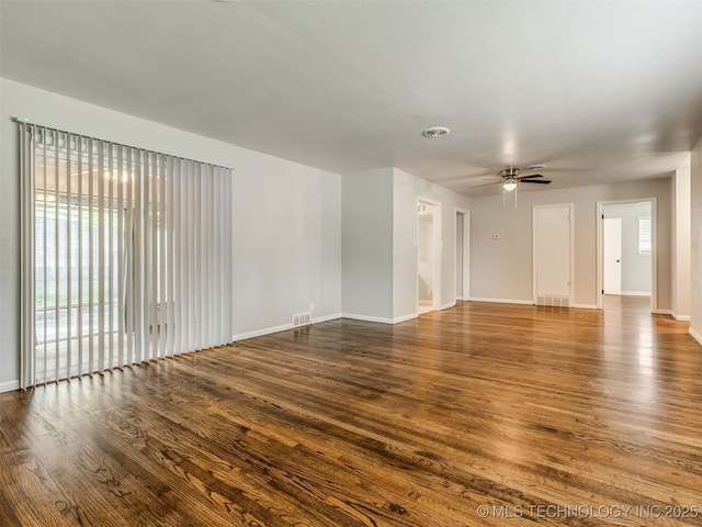 4512 SE Frank Phillips Blvd, Bartlesville, OK 74006 - unfurnished living room featuring healthy amount of natural light, dark wood-style flooring, and a ceiling fan