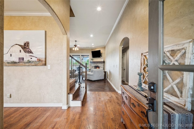 18820 S Kiowa Rd, Claremore, OK 74017 - entrance foyer featuring arched walkways, ornamental molding, a fireplace, wood finished floors, and ceiling fan