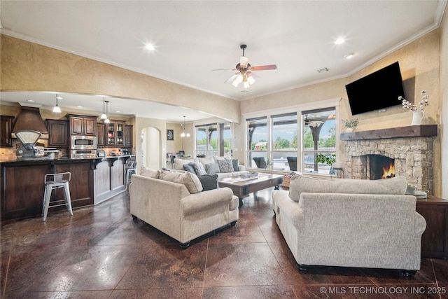 18820 S Kiowa Rd, Claremore, OK 74017 - living room with a ceiling fan, plenty of natural light, a stone fireplace, arched walkways, and ornamental molding