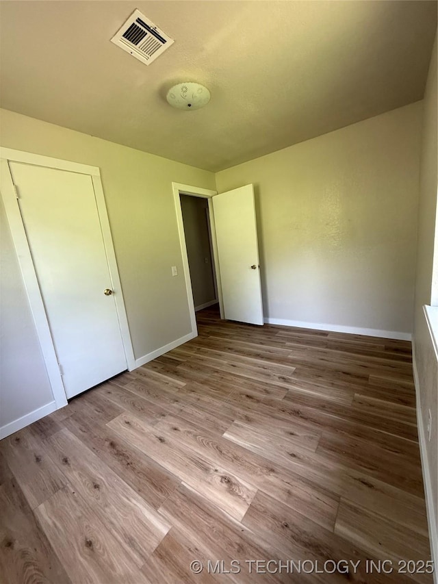 97951 S 4489th Rd, Vian, OK 74962 - unfurnished bedroom featuring wood finished floors