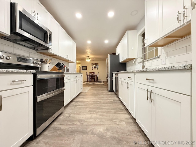1604 N 2nd Ave, Warner, OK 74469 - kitchen with stainless steel appliances, white cabinetry, recessed lighting, and backsplash
