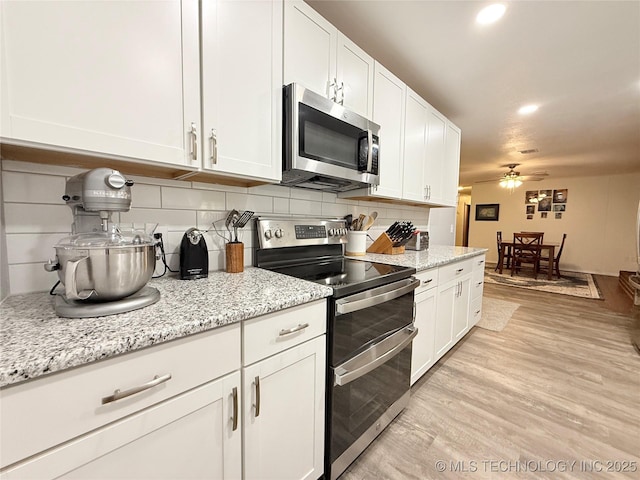 1604 N 2nd Ave, Warner, OK 74469 - kitchen featuring stainless steel appliances, ceiling fan, decorative backsplash, and white cabinetry