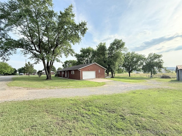 1604 N 2nd Ave, Warner, OK 74469 - view of home's exterior featuring a lawn, brick siding, a garage, and gravel driveway