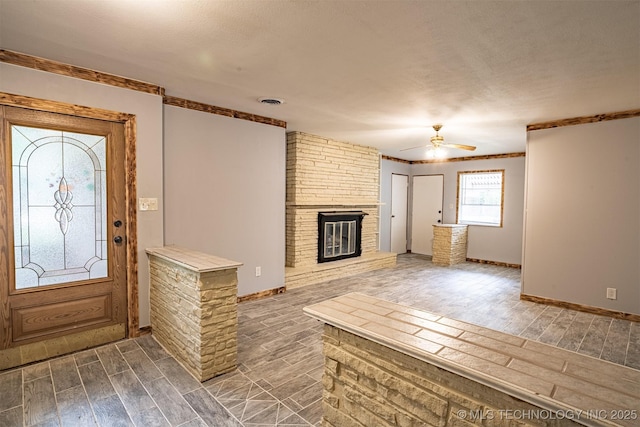 104 Laurel Pl, Bartlesville, OK 74003 - foyer entrance featuring dark wood-style flooring, ceiling fan, a brick fireplace, and ornamental molding