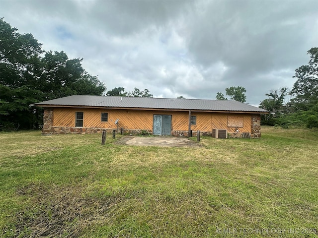 51698 W 139th St S, Drumright, OK 74030 - rear view of house with stone siding, a lawn, a patio area, and a metal roof