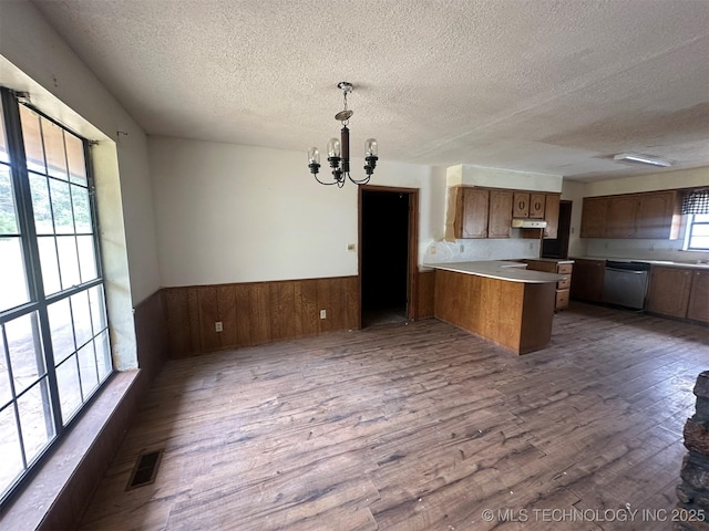 51698 W 139th St S, Drumright, OK 74030 - kitchen featuring stainless steel dishwasher, a peninsula, a textured ceiling, a chandelier, and dark wood-style floors