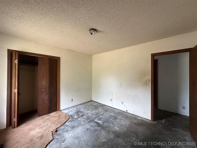 51698 W 139th St S, Drumright, OK 74030 - unfurnished bedroom featuring unfinished concrete floors, a closet, and a textured ceiling
