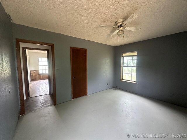 51698 W 139th St S, Drumright, OK 74030 - unfurnished room featuring concrete flooring, a ceiling fan, and a textured ceiling