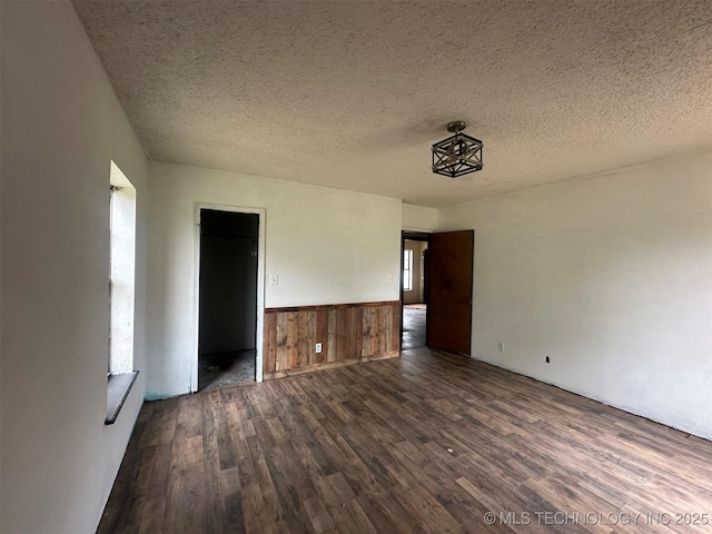51698 W 139th St S, Drumright, OK 74030 - unfurnished room featuring dark wood finished floors, a textured ceiling, and a wainscoted wall