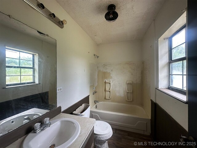 51698 W 139th St S, Drumright, OK 74030 - full bathroom featuring wood finished floors, a textured ceiling, vanity, plenty of natural light, and shower / tub combination