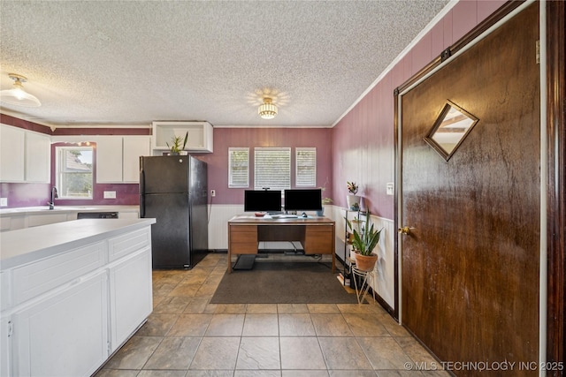 9025 N 156th Rd, Beggs, OK 74421 - kitchen with freestanding refrigerator, a textured ceiling, white cabinets, light countertops, and ornamental molding